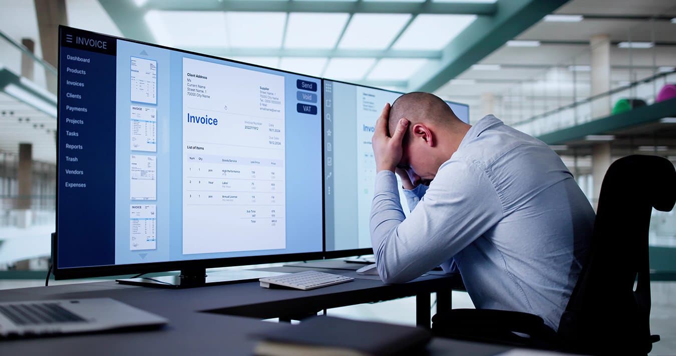 An overwhelmed office worker at a desk full of paperwork